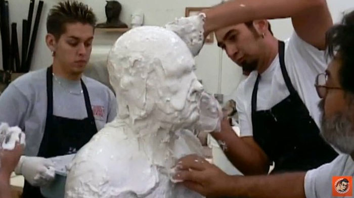 Artists creating a plaster sculpture behind the scenes, an unhinged moment captured for meme potential.
