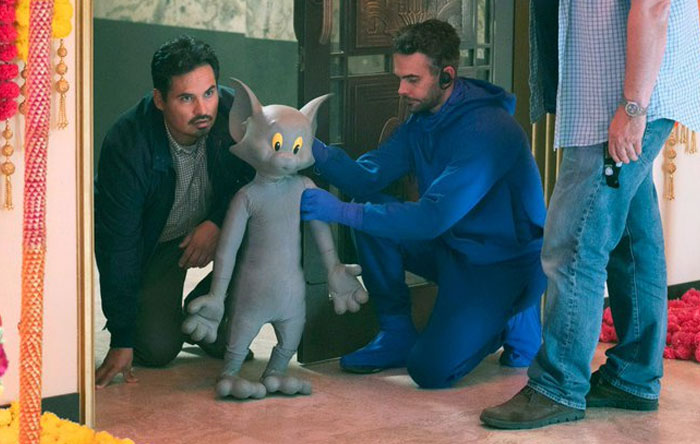 Behind-the-scenes photo showing crew members adjusting a Tom puppet, capturing unhinged moments perfect for memes.