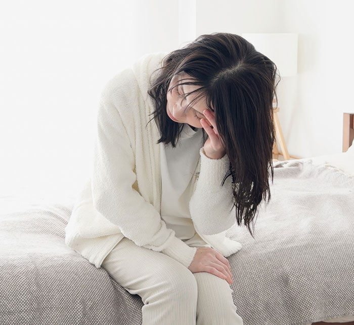 Woman sitting on bed looking distressed, reflecting emotions related to best friend no contact returns situation.