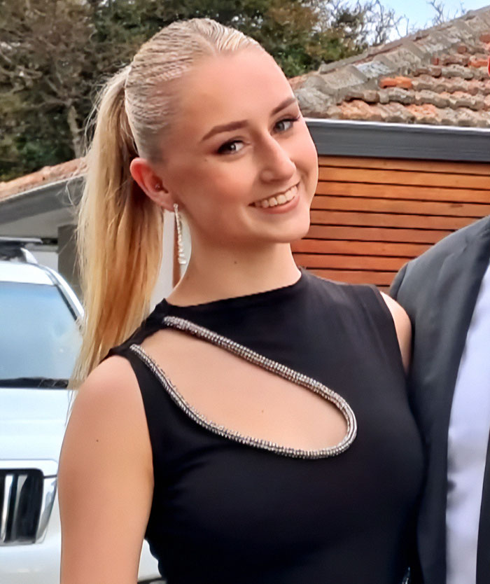 Young woman smiling in a black dress, related to parents warning against travel after daughters lose their lives on vacation.