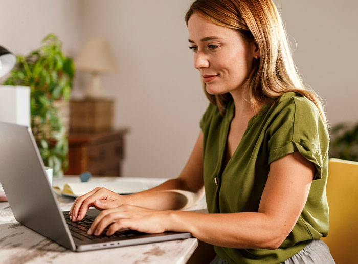 Woman working on laptop at home, illustrating moments when people got truly lucky avoiding difficult situations.