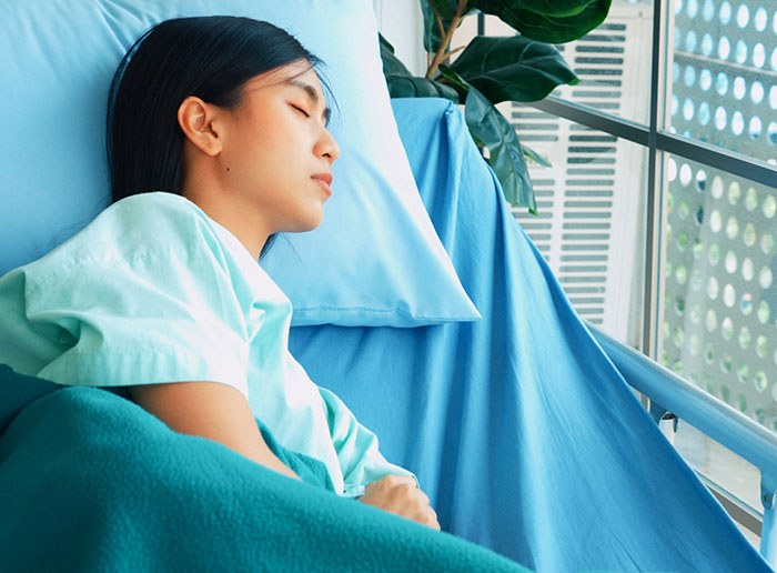 Young woman resting in hospital bed, symbolizing people who got truly lucky avoiding dangerous situations.