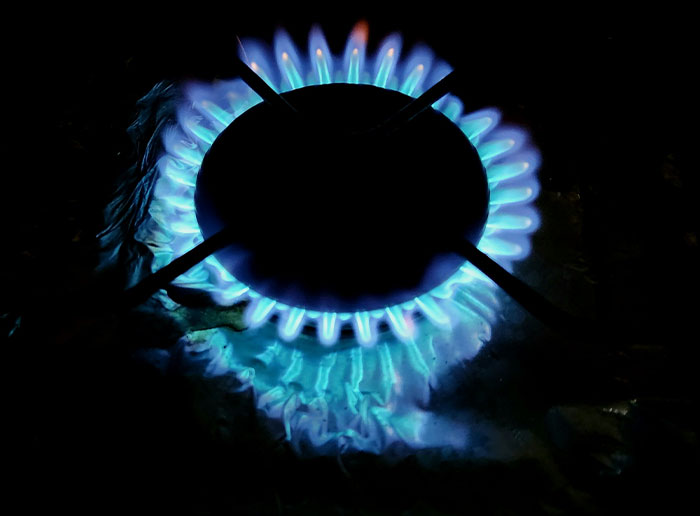 Blue gas burner flame lit on stovetop symbolizing moments when people got truly lucky.