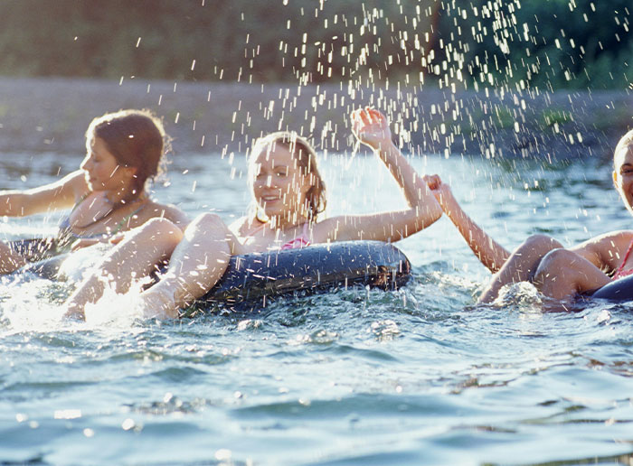 Three people enjoying water tubing, splashing and having fun, capturing moments of truly lucky escape and joy.