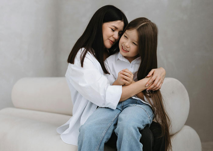 Mother and daughter sharing a warm hug on a couch, illustrating comforting moments amid boyfriend daughter snitch drama. Mother and daughter sharing a warm hug on a couch, illustrating comforting moments amid boyfriend daughter snitch drama.
