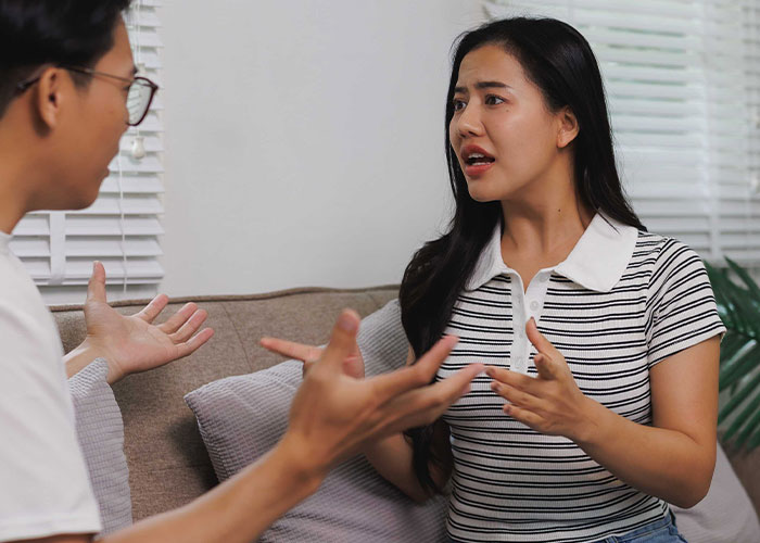 Woman and man having a serious conversation at home, depicting conflict related to her success and new life choices.