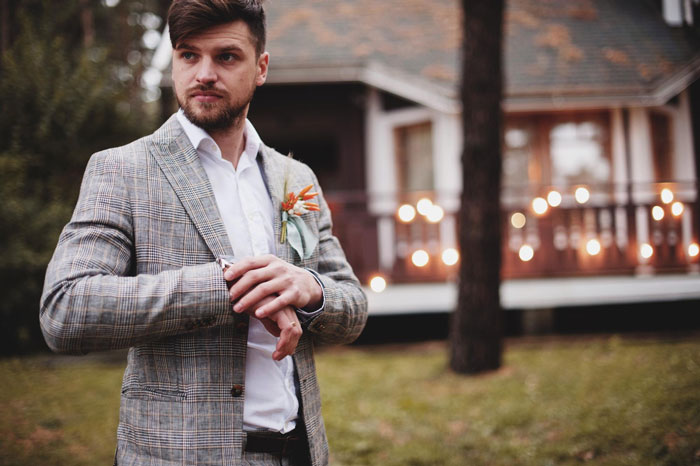 Young man adjusting jacket outdoors near house, depicting brother uses sister&rsquo;s credit card without permission concept