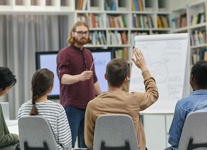 Man leading a discussion with participants raising hands, illustrating unexpected stories of bad days turning life-changing.