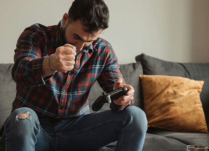 Man showing frustration while playing video games on a couch, illustrating unexpected stories of a bad day turning life-changing.