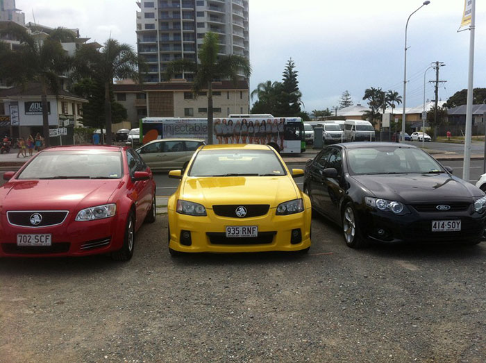 Three parked cars in a row in a gravel lot by a street, illustrating businesses that lost clients with poor decisions.