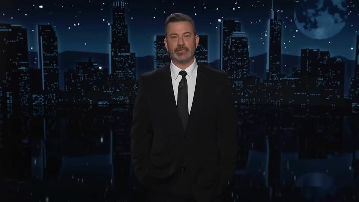 Man in a black suit speaking on a nighttime cityscape background about businesses that lost clients with poor decisions