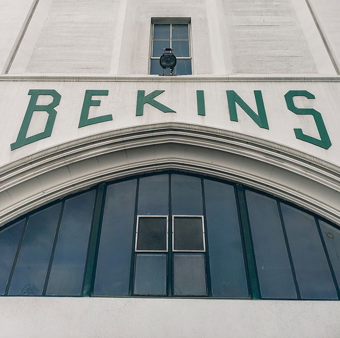 Historic business building facade with large BEKINS sign and arched windows, illustrating businesses losing clients.