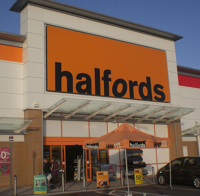 Halfords store exterior with orange signage and promotional tents, illustrating businesses that lost clients with poor decisions.