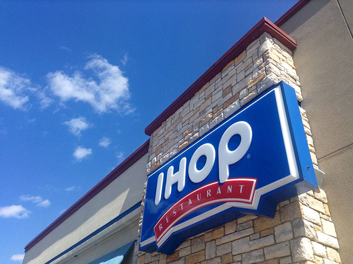 IHOP restaurant sign on building exterior under blue sky illustrating businesses that lost clients with bad decisions.
