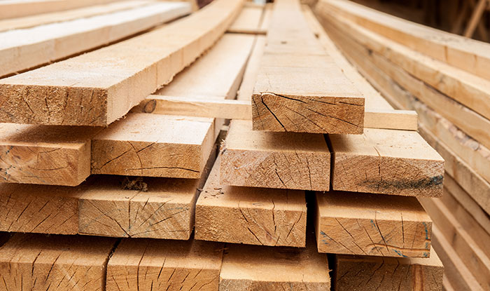 Stack of wooden planks bundled in a workshop, related to businesses that lost clients with poor decisions.