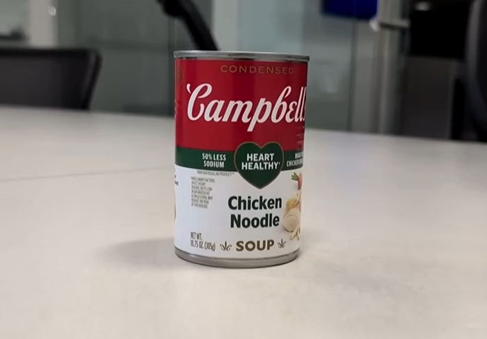 Can of Campbell's Chicken Noodle Soup placed on a table highlighting disturbing comments about the soup's ingredients.