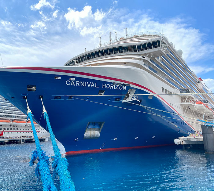 Cruise ship docked at port with clear sky, related to stepbrother of teen slain in cruise incident and obsession details.