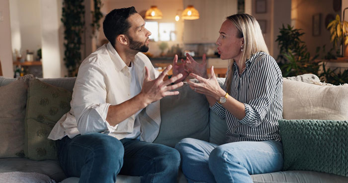 Couple arguing passionately on couch about mom&rsquo;s native language being pointless and banned from use with daughter.