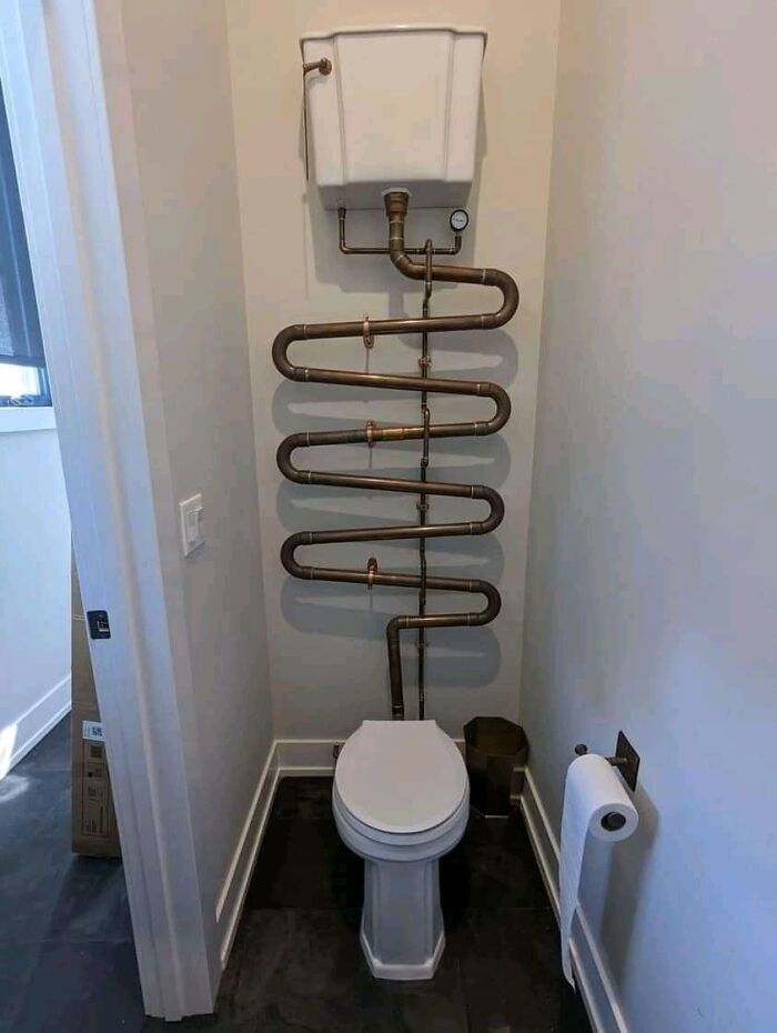 Toilet with an overly complicated and poorly executed plumbing system, showcasing job done so poorly it is almost impressive.