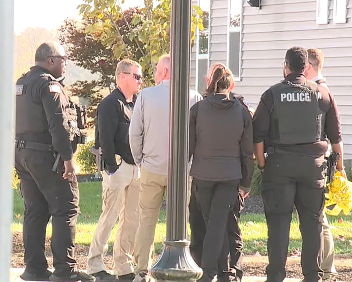 Police officers and investigators gather outside a house related to cleaning lady tragic incident involving four kids.