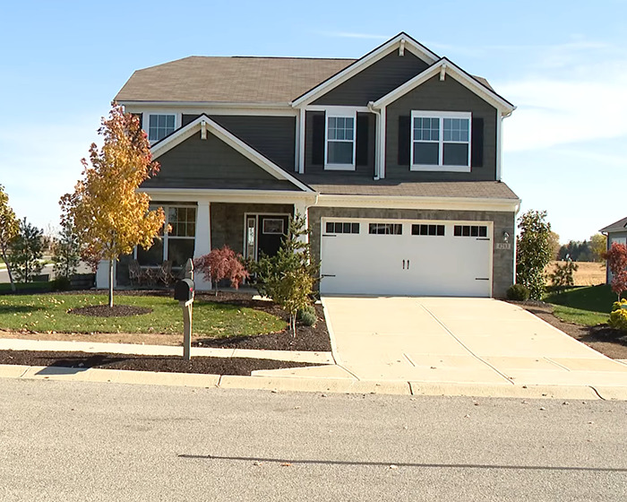 Modern two-story suburban house with a driveway and fall trees, related to cleaning lady loses her life tragedy news.