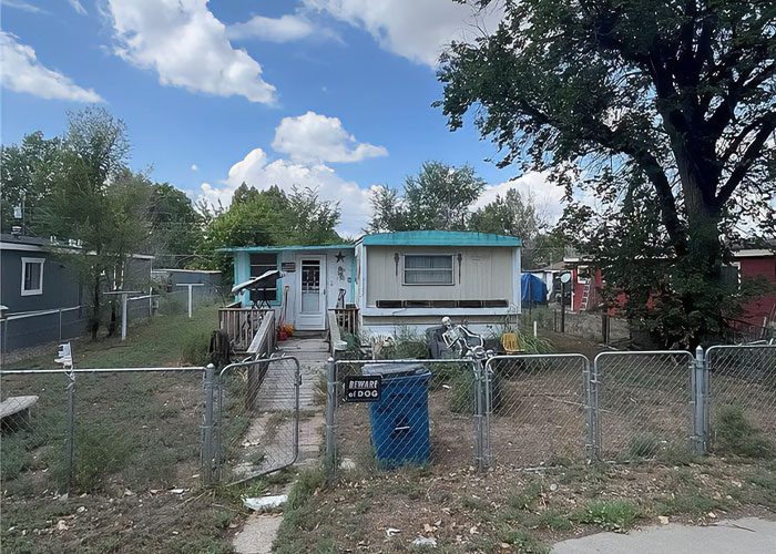Small house with fenced yard and "Beware of Dog" sign, related to missing woman&rsquo;s body discovered in garage case.