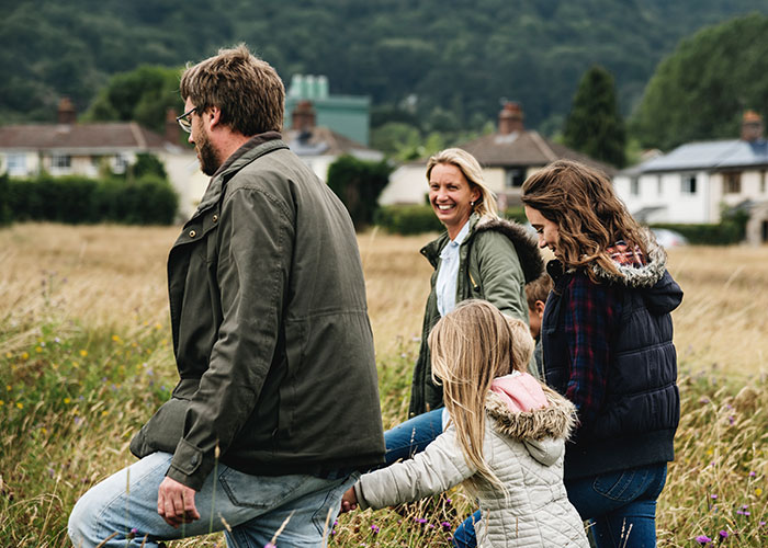 Family enjoying a nature walk in a rural area, highlighting lifestyle differences in the debate of life in the USA versus Europe.