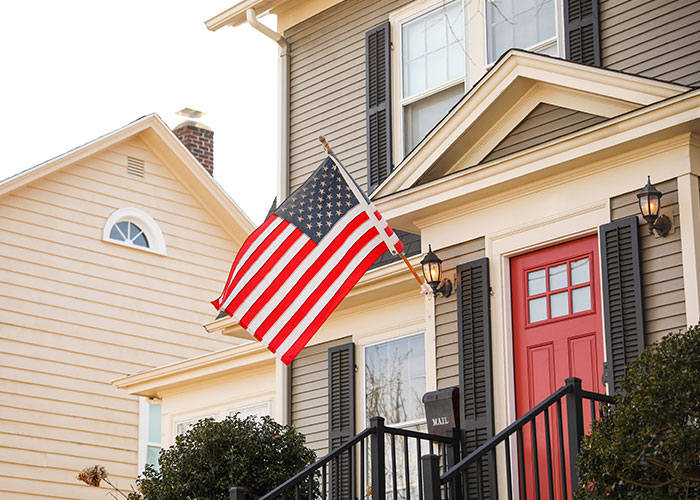 American flag displayed outside a suburban home, symbolizing the life debate between the USA and Europe.