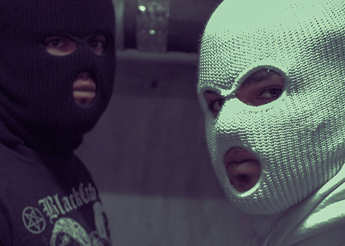 Two people wearing dark and light knitted masks, fitting the theme of weirdest and craziest ER stories.