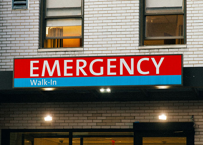 Emergency room entrance sign on a brick building highlighting weirdest and craziest ER stories experiences.