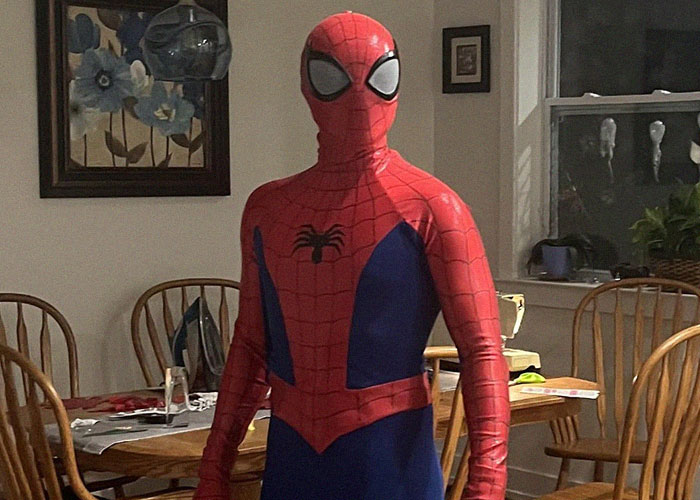 Person dressed in a Spider-Man costume standing in a dining room, illustrating narrowly avoided kidnapping stories online.