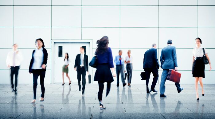Busy professionals walking in a modern office building hallway illustrating work secrets and career insights.