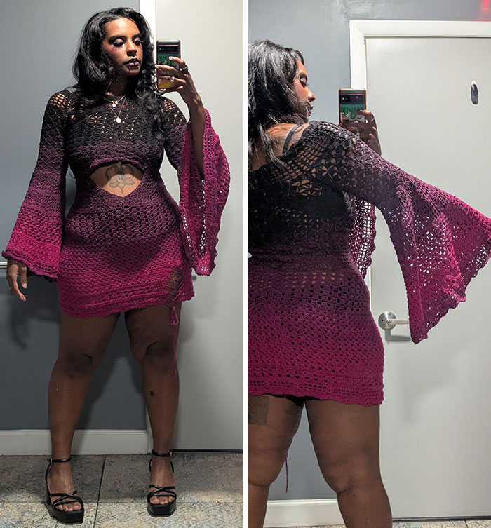 Woman wearing a handmade crochet dress with bell sleeves, showcasing a proud crochet enthusiasts project in front of a mirror.