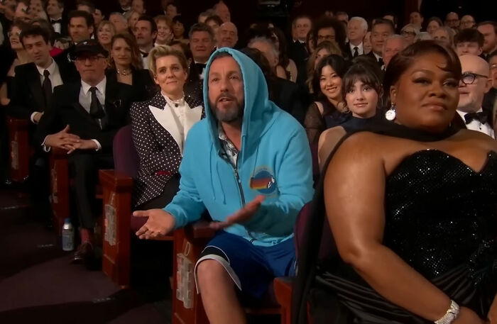 Brad Pitt wearing a blue hoodie and shorts at a Hollywood premiere, sparking speculation about his appearance.