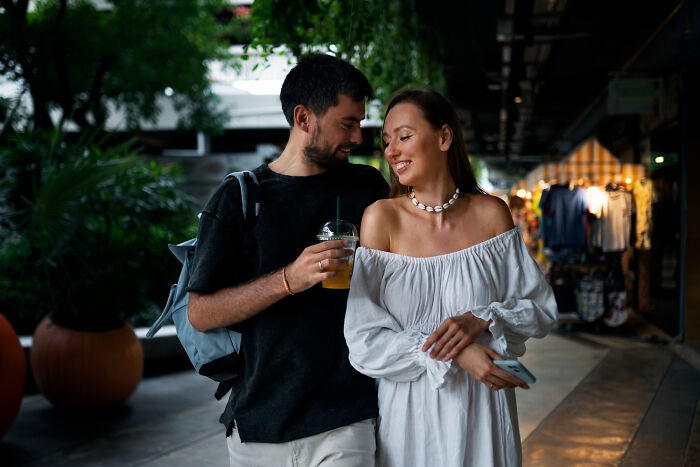 Couple enjoying a casual outing, smiling and holding drinks, illustrating dating older people stories single lifestyle.