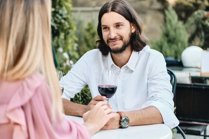 Couple dating older people stories single sharing a romantic outdoor moment with wine at a cafe table.