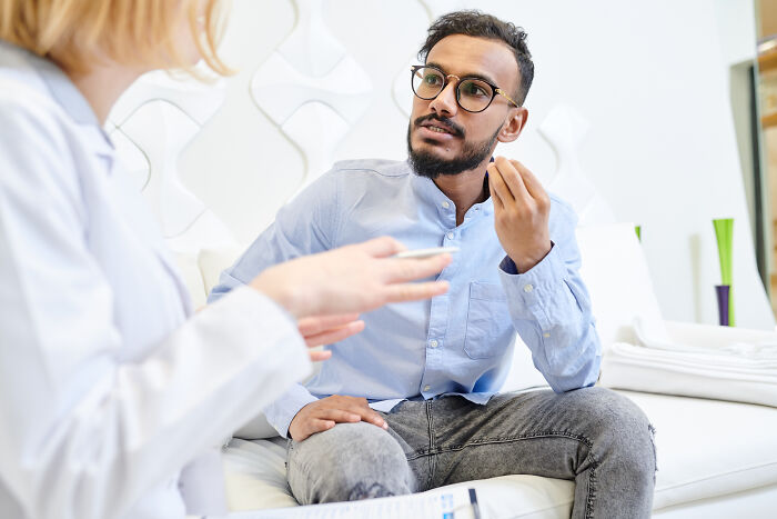 Doctor listening intently to patient sharing eerie stories during a consultation in a bright medical office.