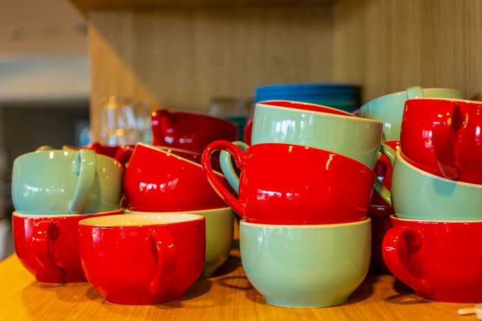 Stacked red and green cups on a wooden surface revealing surprising habits discovered after moving in with a partner
