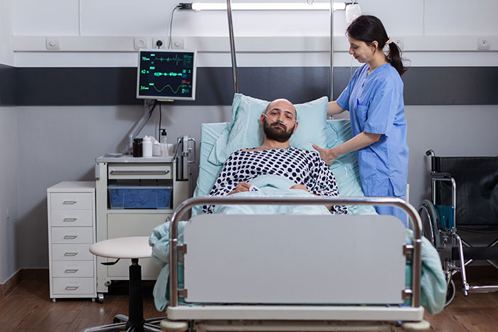 Doctor in blue scrubs attending to a patient in a hospital bed, highlighting surgeons and doctors recalling mistakes.