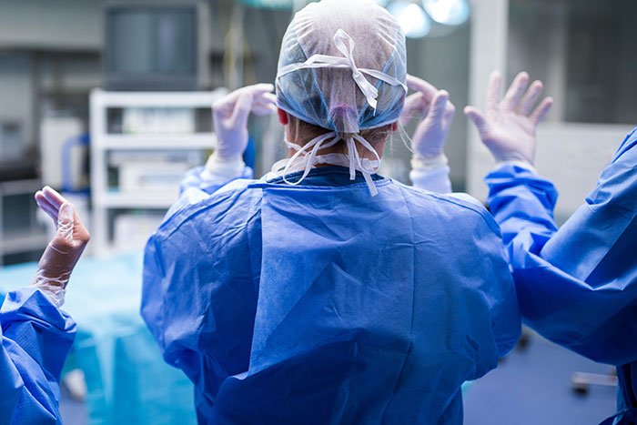 Doctors in surgical scrubs and gloves preparing in an operating room, highlighting medical errors and mistakes.