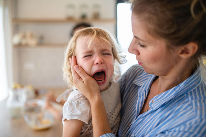 Mom comforting her crying child after a dog bite incident caused by negligent owners ignoring the situation. Mom comforting her crying child after a dog bite incident caused by negligent owners ignoring the situation.