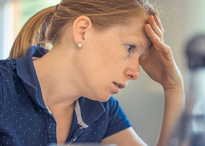 Woman stressed at home as MIL schedules important family events on her work days prioritizing work over family.