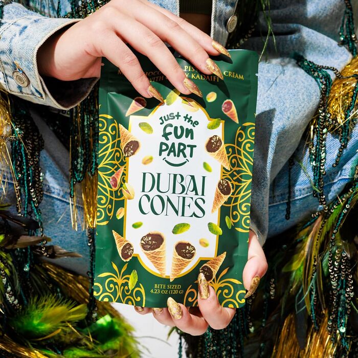 Hand holding a green bag of Dubai Cones snack, a unique gift idea for people who are impossible to shop for.