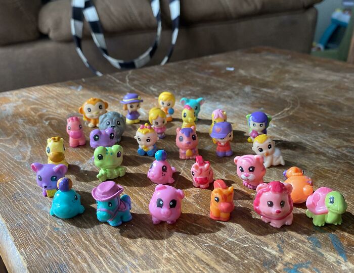 Colorful small figurines arranged on a wooden table, representing playful characters related to nepo babies insider experiences.