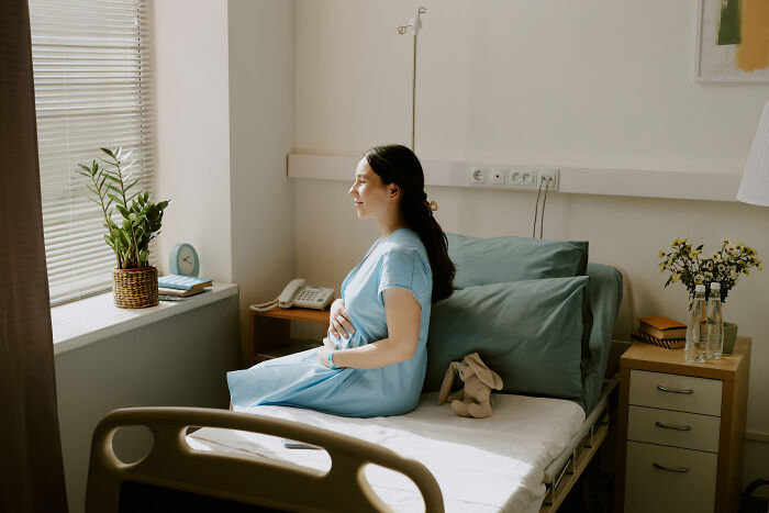 Paciente embarazada en hospital, antes de una consulta médica que podría causar momentos embarazosos en visitas al doctor.
