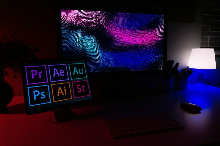 Dark workspace with a colorful digital art display on a monitor, illustrating the theme of babysitting refusal and unemployment debate.