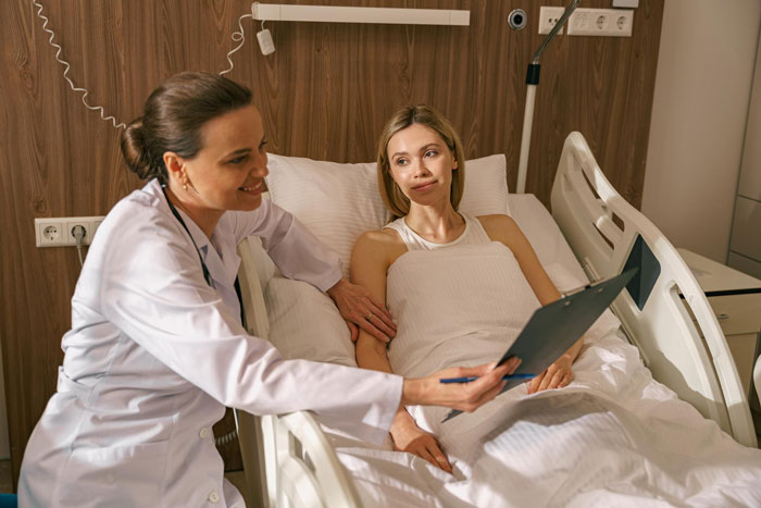 Doctor explaining medical chart to female patient in hospital bed, highlighting Karen patient behavior in ER setting.