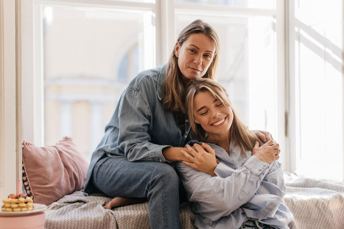Woman comforting her daughter in a cozy home setting, symbolizing healing from toxic guy's impact on family life.