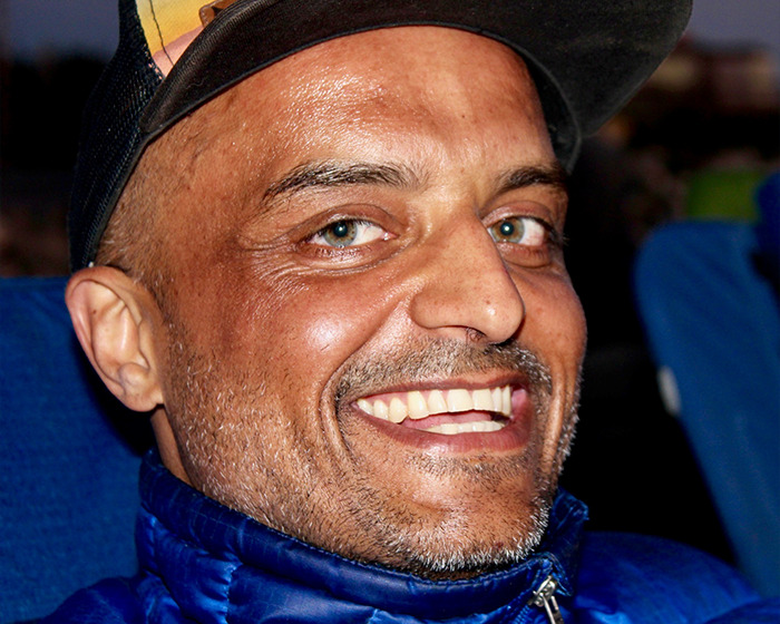 Close-up of a smiling man wearing a cap, representing ex-employees who kidnapped a toxic tech CEO story.