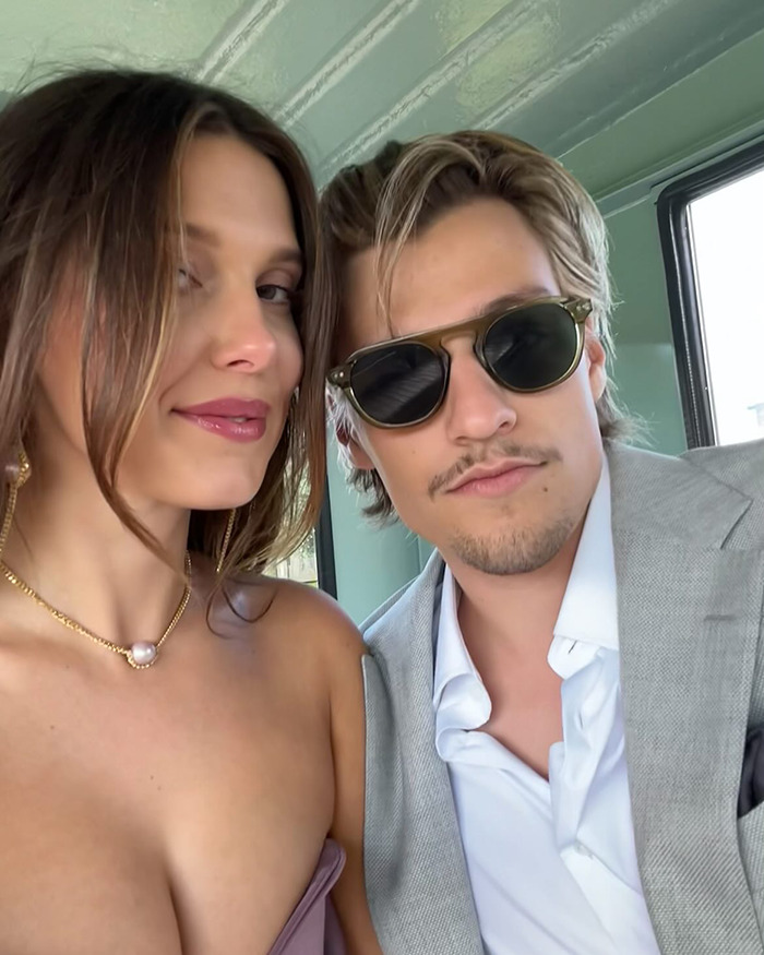 Millie Bobby Brown and Jake Bongiovi posing together selfie indoors, fans reacting to their dating story online.